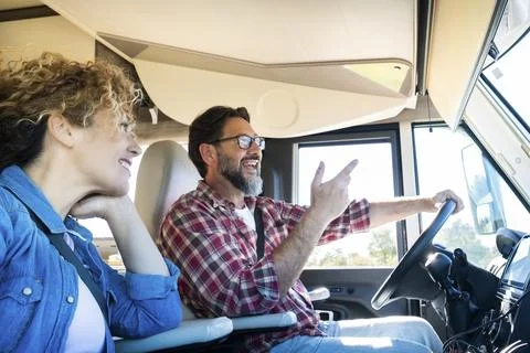 Man driving camper smiles while driving with his wife company. Concept of t.. Stock Photos