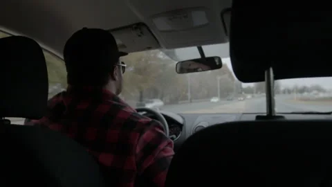 Man Driving Car Along Suburban Road Viewed from Backseat Stock Footage 343936282