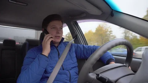 A man is driving a car and talking on his mobile phone. Stock Footage 81232471