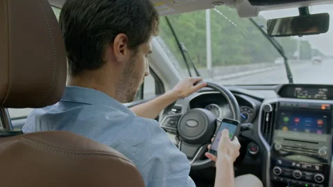 Man driving car and texting message on mobile phone in motion Stock Footage 263223790