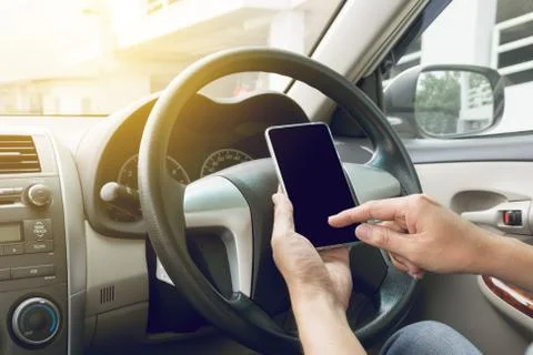 Man driving car and using mobile phone Stock Photos