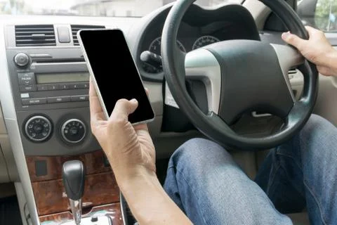 Man driving car and using mobile phone Stock Photos