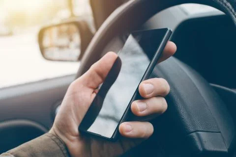 Man driving car and using mobile phone for texting 스톡 사진