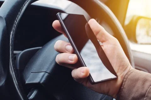 Man driving car and using mobile phone for texting 스톡 사진