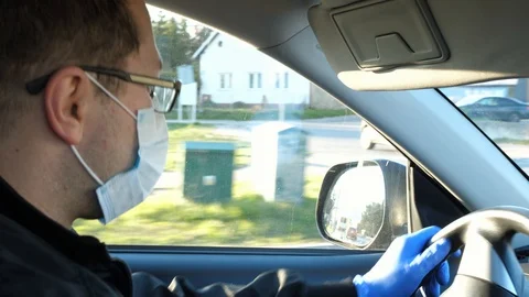 Man driving car driver in a car wearing mask and protective gloves Stock Footage 128879261