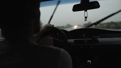 Man driving a car in the rain in the windshield dripping water Stock Footage 111698363