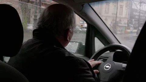 Man Driving Car on Rainy Day in City Stock Footage 343097939