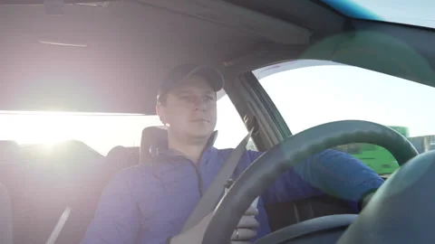 A man is driving in the car at sunset. Stock Footage 88300456