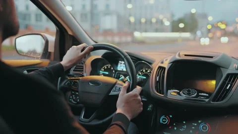 Man driving car through the streets of evening city. City lights, cars, traffic Stock Footage 201270937