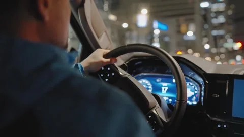 Man driving car through the streets of night city. Stock Footage 242480720