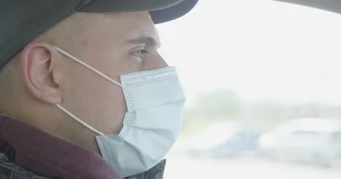 Man driving car wareing mask close up covid 19 pandemic crisis Vídeo Stock 127854464