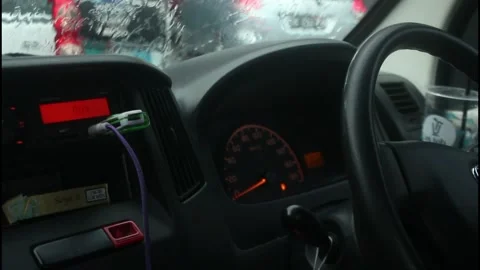 A man is driving a car while playing on his cellphone when it rains. Stock Footage 266683183