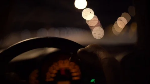 Man driving car through tunnel in night time with blurred street light bokeh Stock Footage