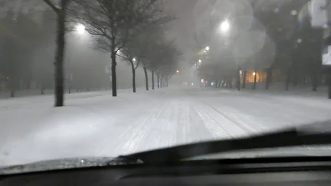 Man driving during snowstorm Stockbeeldmateriaal 125548674