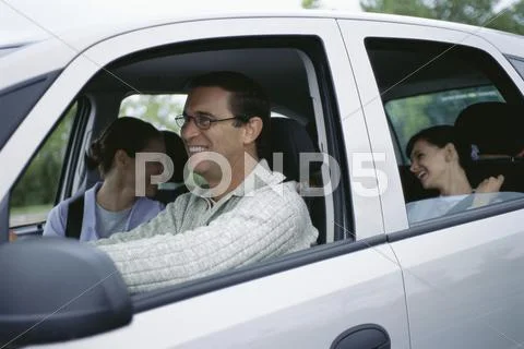 Man Driving Family On Road Trip