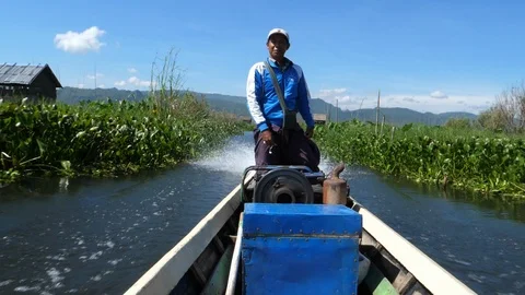 A man driving his boat on floating burmese gardens, Asia in HD Slow motion Stock Footage 95197576