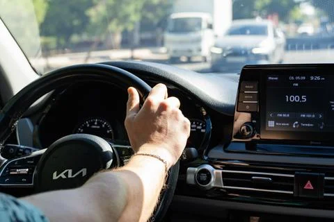 Man driving a Kia car on a sunny day view from inside Stock Photos