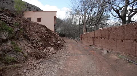 A man driving a light motorcycle in a small village in the Atlas mountains Stock Footage 45049062
