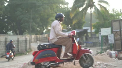 Man driving red scooter on road Stock Footage 85777110