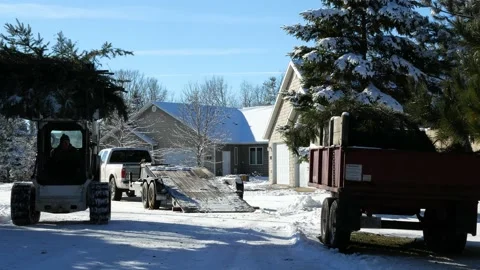 A man is driving small front loader machine and unloading tree branches Stock Footage 131690388