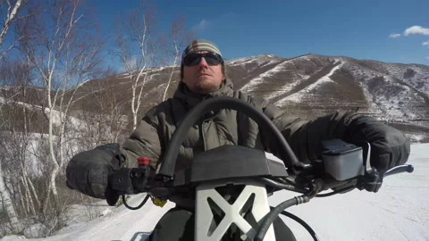 Man driving a snowmobile speeding in a ski resort,Zhangjiakou, China Stock Footage 135246734