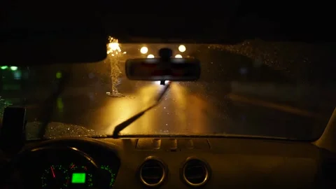 Man driving through a heavy rain storm in a dark rainy city. Night lights and Stock Footage 168067857