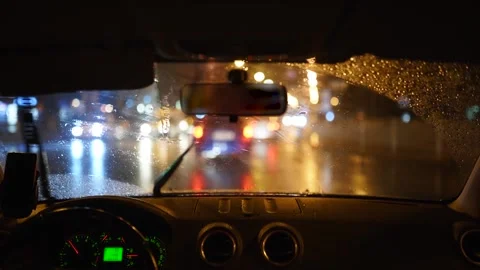 Man driving through a heavy rain storm in a dark rainy city. Night lights and Stock Footage 168120312