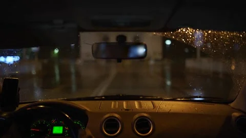 Man driving through a heavy rain storm in a dark rainy city. Night lights and Stock Footage 175418626