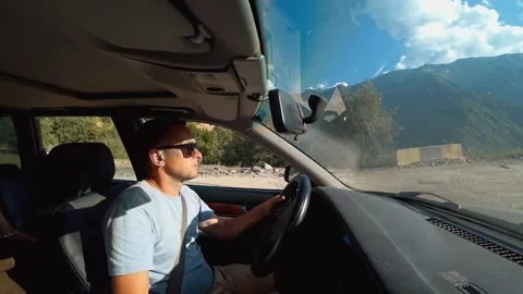Man driving through scenic mountain road in bright sunlight 스톡 동영상 301697211