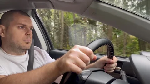 Man driving, view inside the car as a driver focuses on the road ahead duri.. Stock Footage 252380479