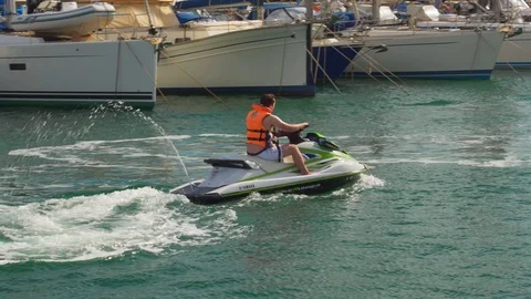 Man  driving  water scooter through Valencia yacht shore. Stock Footage 119284380