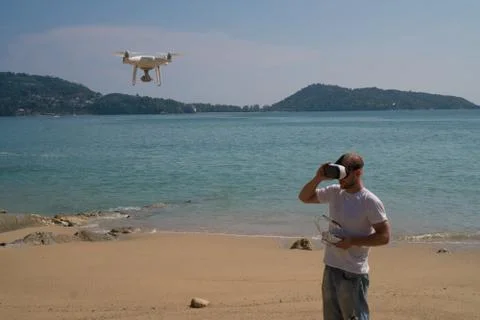 Man with drone camera and virtual reality glasses on the beach Stock Photos