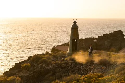 Man with drone next to Lighthouse at sunset in Tenerife Stock Photos
