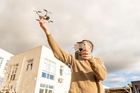 Man drone operator catching UAV with hand, photography and videography from s Foto stock