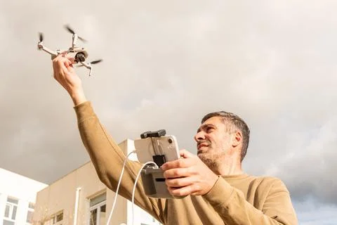 Man drone operator catching UAV with hand, photography and videography from s Foto stock