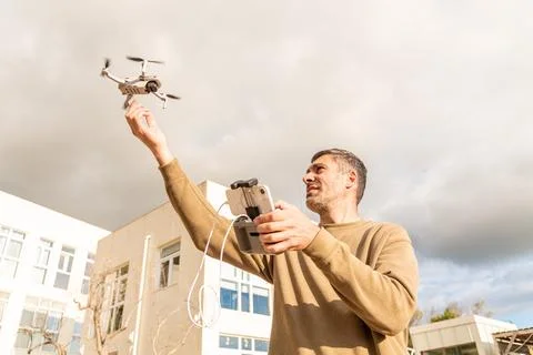 Man drone operator catching UAV with hand, photography and videography from s Foto stock