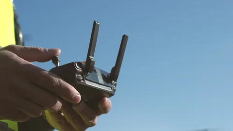Man drone operator controls an aircraft remote control on a sunny day Stockbeeldmateriaal 116486517