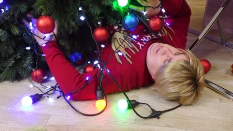 Man dropped decorated Christmas tree with garland on floor, lies , drunken guest Stock Footage 284285355