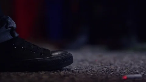 Man dropping a cigarette beside shoe close up at night Stock Footage 84666891