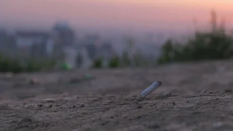 Man dropping a cigarette on a ground in slow motion Stock Footage 76381843