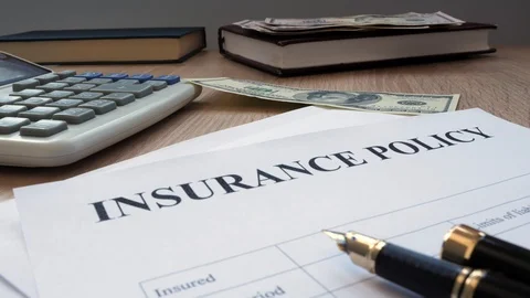 Man dropping dollar bills on an insurance policy. Stock Footage 87568012