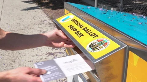A man dropping his ballot off in curbside drop box to vote in a local election Stock Footage 196848530