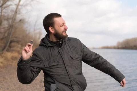 Man dropping a stone into the river Foto stock