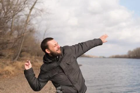 Man dropping a stone into the river Stock Photos