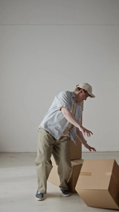 Man Dropping Tall Stack of Cardboard Boxes during Relocation Stock Footage 342590349