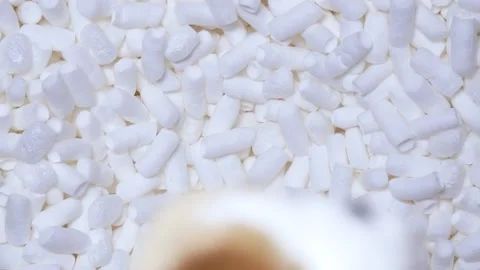 The man drops old toy into a box of soft filler and foam sticks in slow motion. Stock Footage 197572875
