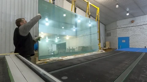 A man drops out of a drawer a large sheet of glass on the table. Stock Footage 123952152