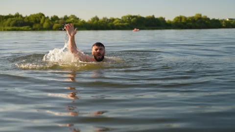 Man drowning in lake waving for help Stock Footage 317122981