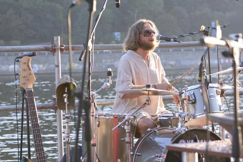 Man drummer playing drum on the beach, Dnipro river on a background. Kyiv Stock Photos