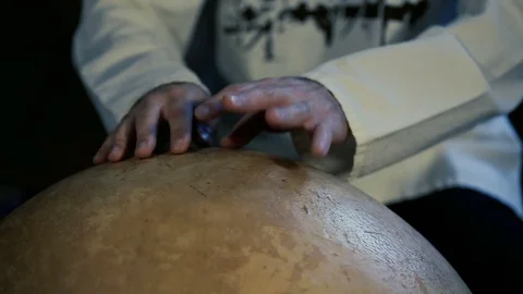 Man drumming out a beat on an arabic percussion drum named Calabasse at home. Video stock 74519412